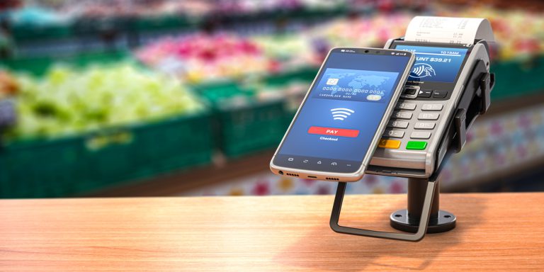 Contactless payment with smart phone. POS terminal with NFC mobile phone in asupermarket.
